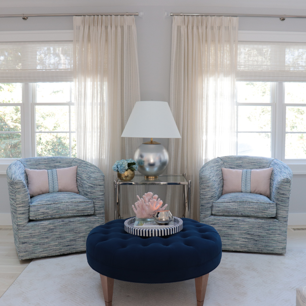Living room with two armchairs and a navy ottoman.