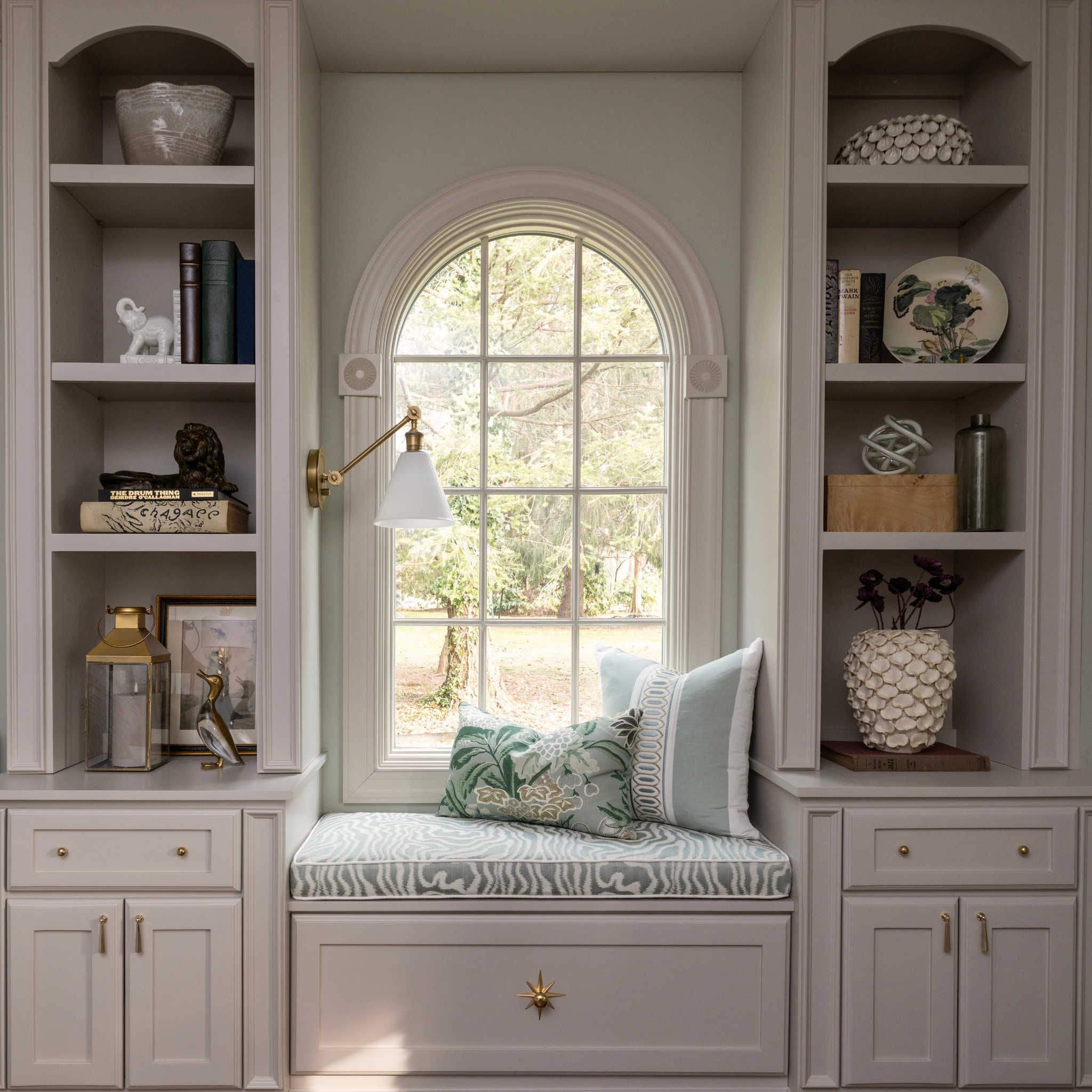 Cozy nook with built-in shelves, a window seat, and decorative pillows.