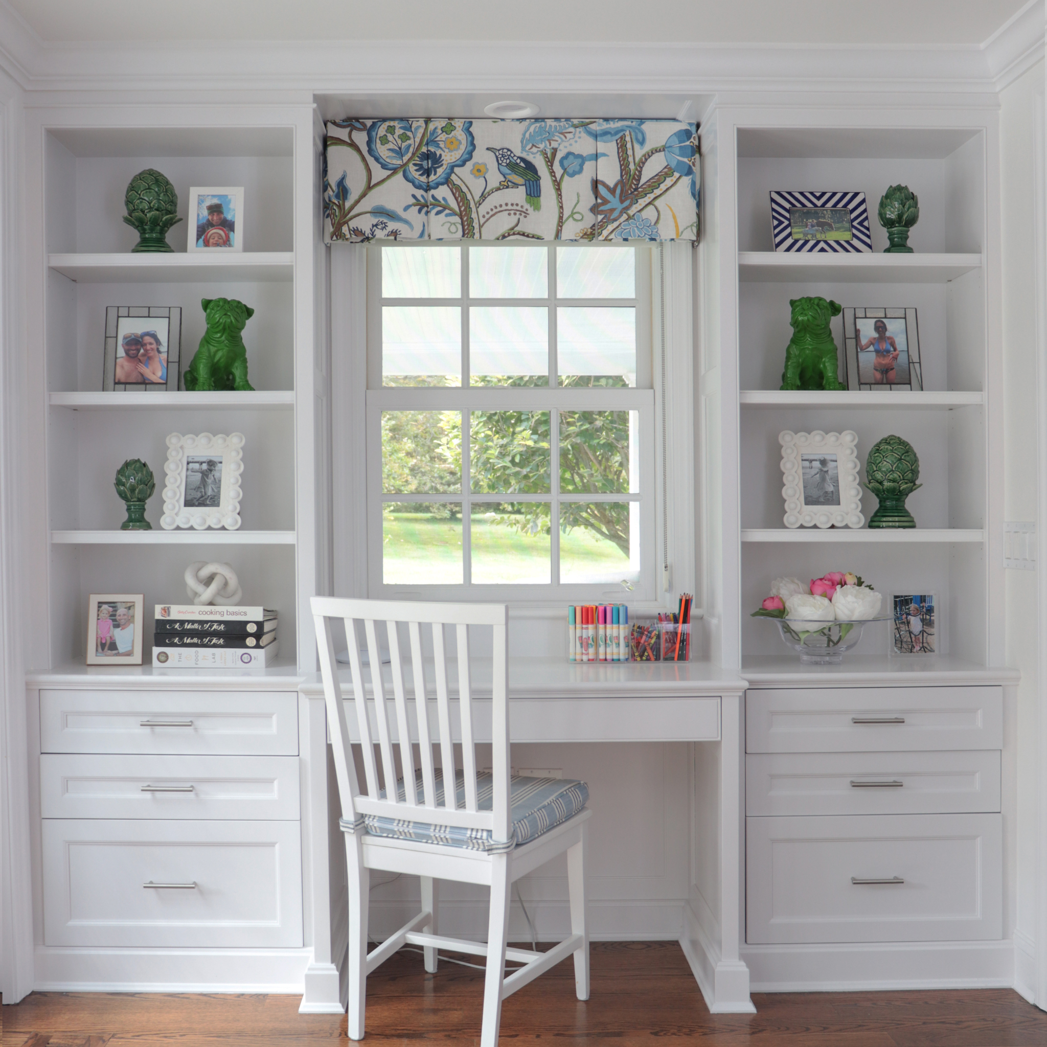 Home office with white desk, chair, and bookshelves.