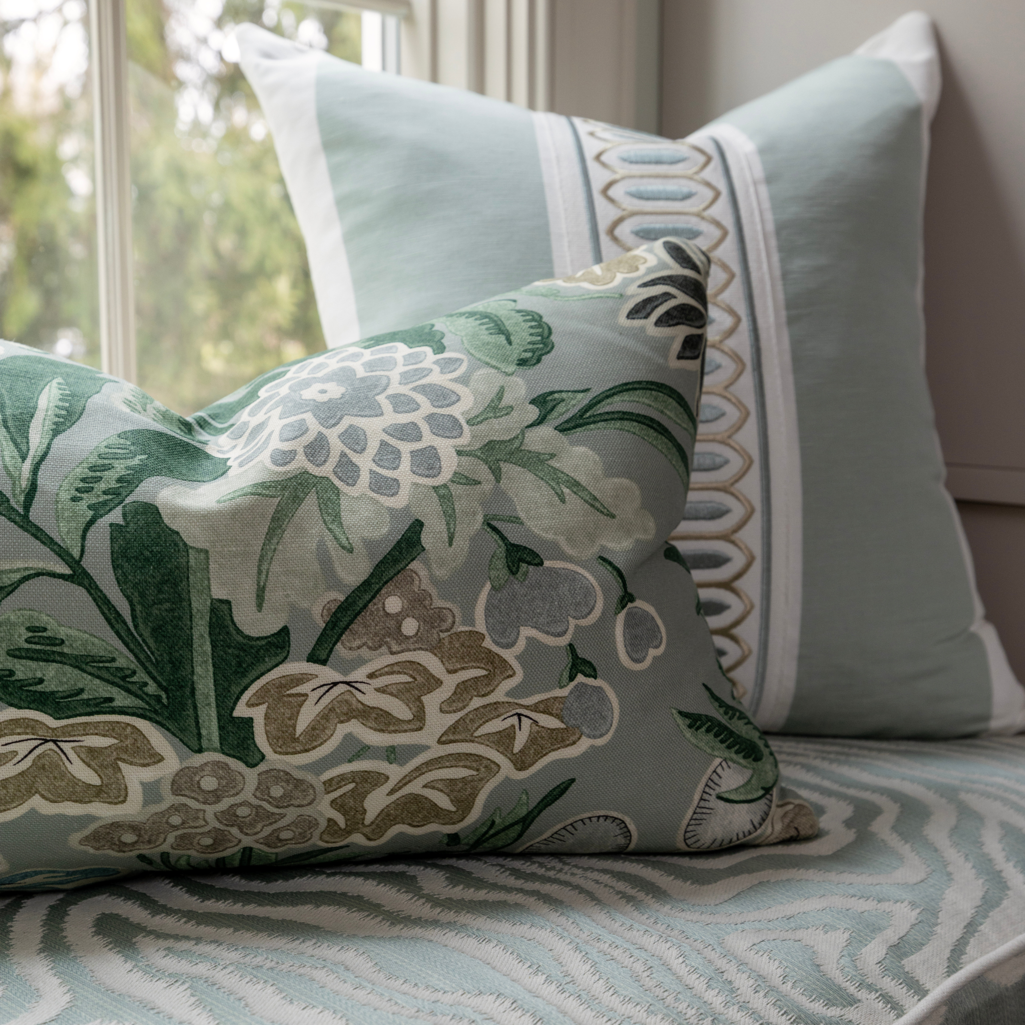 Decorative pillows with floral and geometric patterns on a sofa.